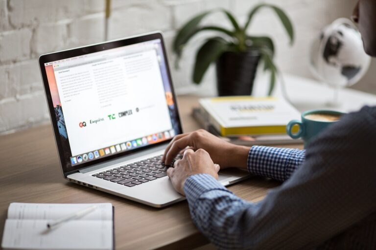 Man reading business email on white laptop