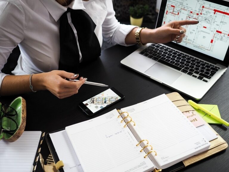 Person pointing finger at digital construction plan in laptop