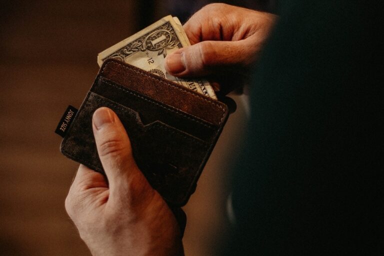 A dollar bill being pulled from a wallet